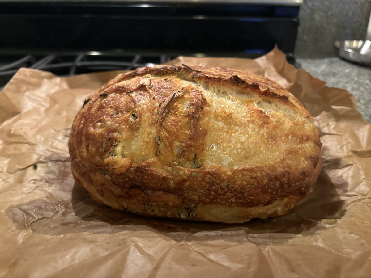 Herb and cheese sourdough with rosemary on parchment